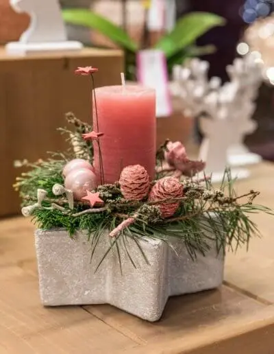 Adventsgesteck mit korallfarbener Kerze