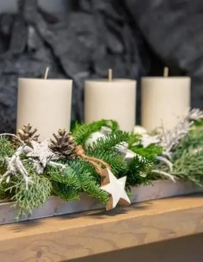 Weißes Adventsgesteck mit Zapfen