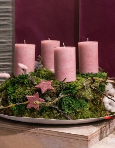 Adventskranz auf Teller mit rosanen Kerzen